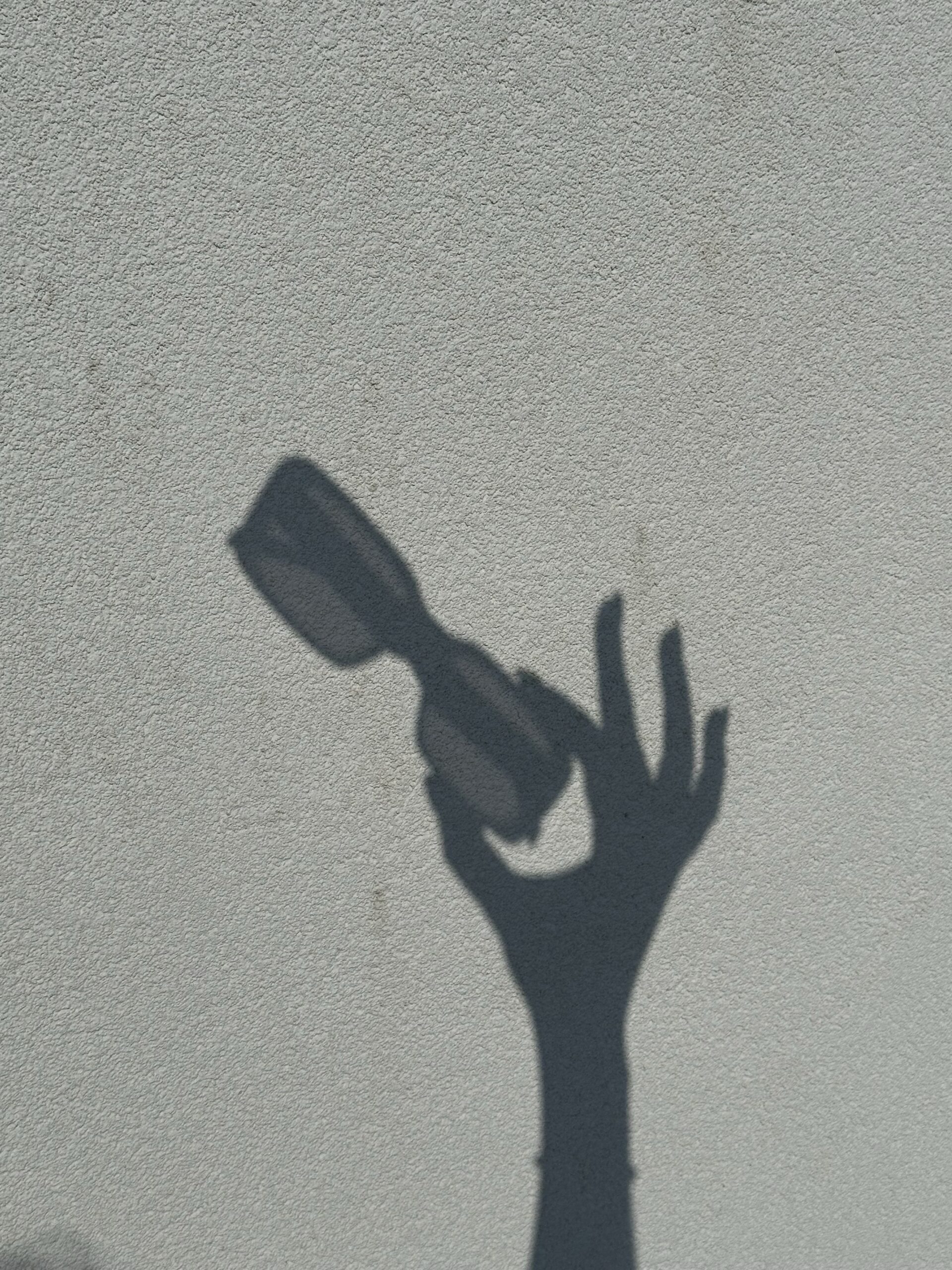 shadow of a hand holding sunglasses