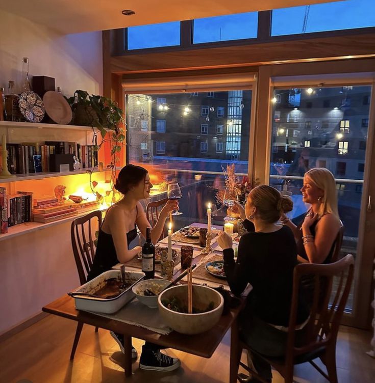 three women sitting at a table enjoying dinner together