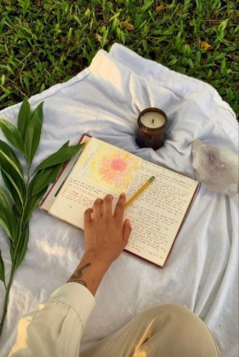 journal, candle, and crystals on a sheet on the ground